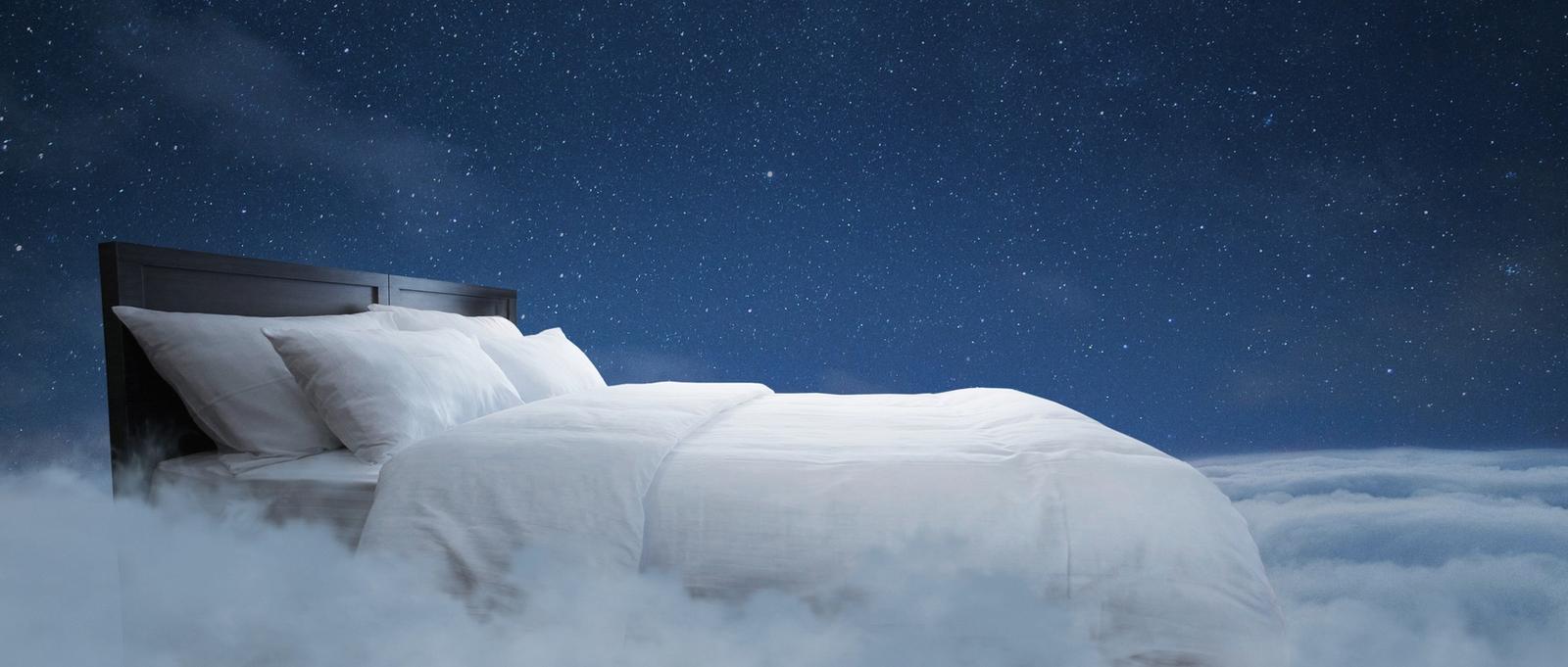 Bed with pillows and a blanket flies in the clouds with a night starry sky with the moon, creative idea. Sweet dream, concept. Night rest